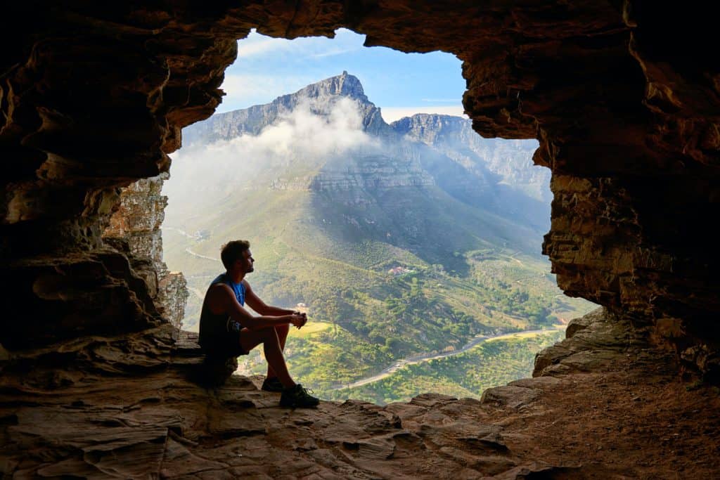 photo of man sitting on a cave 1659437 man in a cave